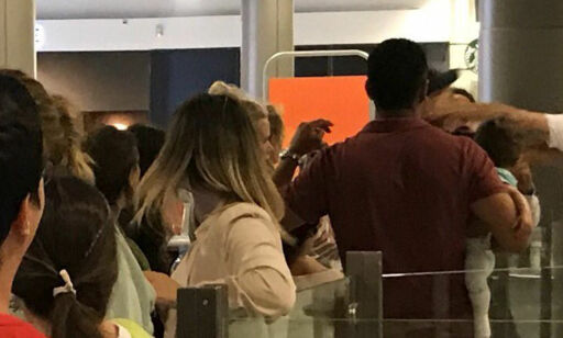 Her blir mannen med en baby på armen slått til av flyplassansatt